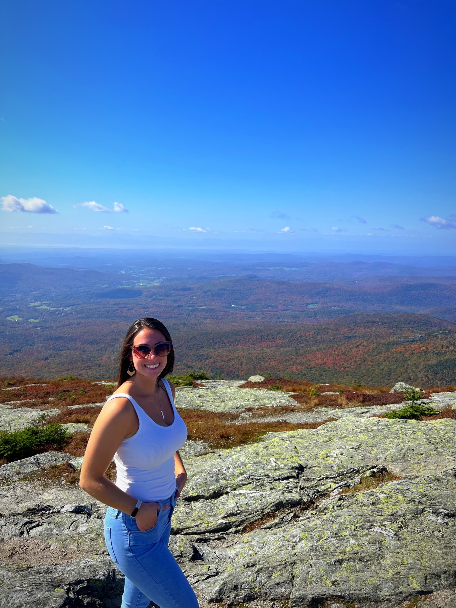 Ashley Noelk stands at the top of a mountain in Vermont